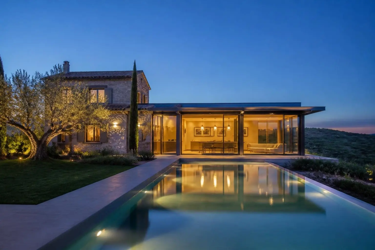 Istrisches Steinhaus mit modernem Glasanbau, Pool und Olivenbäumen in der Abenddämmerung